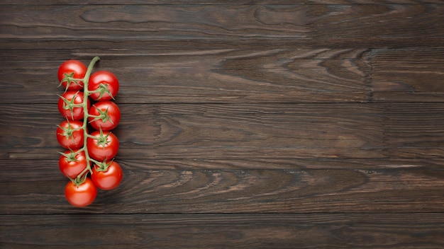 Branche de tomates cerises sur fond de bois