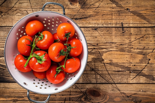 Branche de tomates cerises rouges dans une passoire