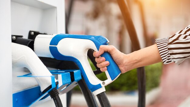 Branchement manuel d'un chargeur dans une prise de voiture électriqueLa voiture électrique ou le véhicule électrique se recharge à la station xA