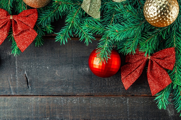 Branches d'un arbre de Noël et décorations de Noël sur un fond en bois, vue du dessus