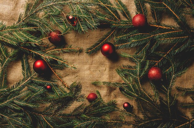 Branches d'arbres de Noël et boules comme décoration sur fond de jute