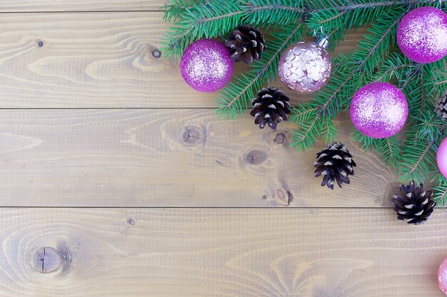 Branches d'arbres de Noël avec des décorations rouges sur un fond de mur en bois. Modèle pour carte de voeux ou design. Bannière virtuelle avec espace de copie.