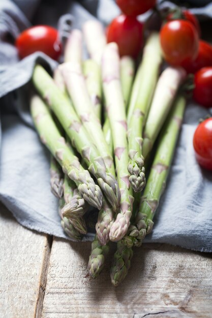 Photo branches d'asperges vertes fraîches sur table en bois