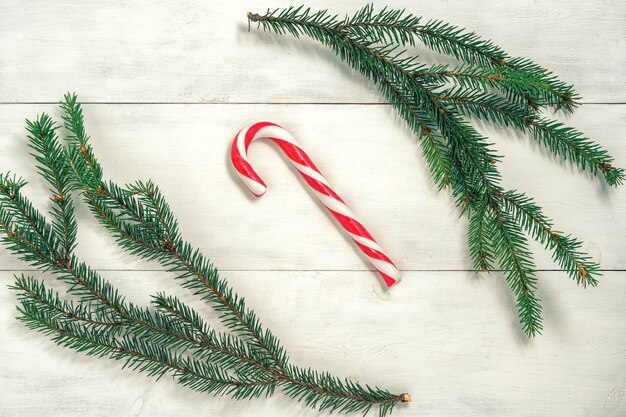 Photo branches d'épinette et canne à sucre sur table blanche en bois.