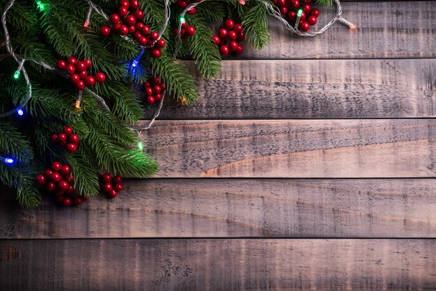 Branches d&#39;épinette de Noël et fruits rouges sur bois.