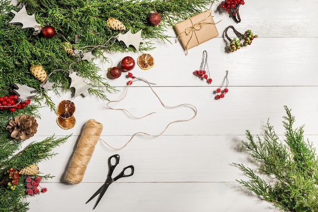 Branches de genévrier avec un décor de Noël. Noël, fond de nouvel an. Branches de conifères de genévrier. Vue de dessus, design plat. Arbre de Noël sur fond en bois blanc.