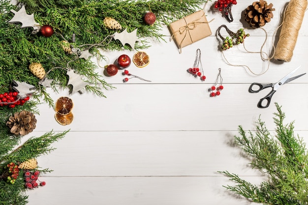 Branches de genévrier avec un décor de Noël. Noël, fond de nouvel an. Branches de conifères de genévrier. Vue de dessus, design plat. Arbre de Noël sur fond en bois blanc.