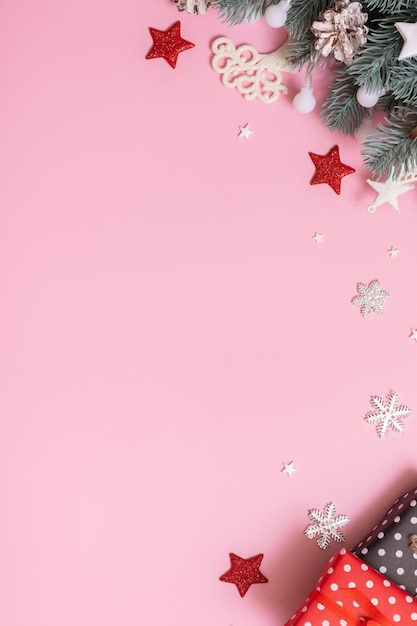 Branches de pins avec décoration du Nouvel An Cristmas vue de dessus mise à plat sur fond rose avec espace de copie Carte de vœux vierge