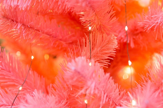 Branches rouges de sapin de Noël avec des lumières jaunes. Épicéa décoratif