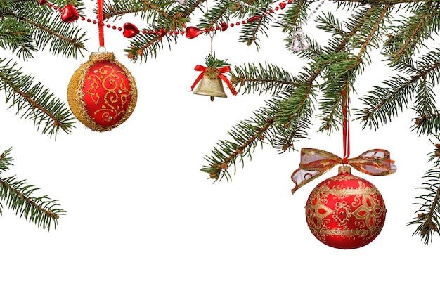 Branches de sapin avec des boules, des cloches et d'autres ornements de Noël sur fond isolé blanc