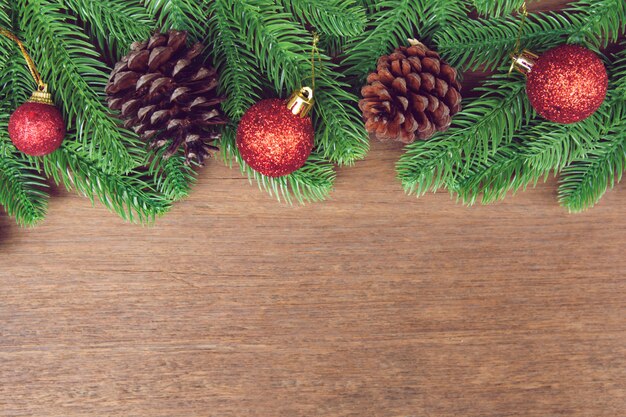 Branches de sapin et pommes de pin avec décoration sur une planche de bois