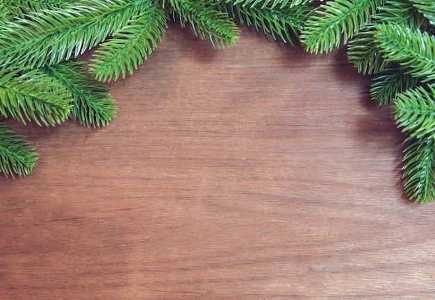 Branches de sapin et pommes de pin avec décoration sur une planche de bois.