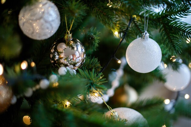 Branches vertes d'un arbre de Noël décorées de boules blanches