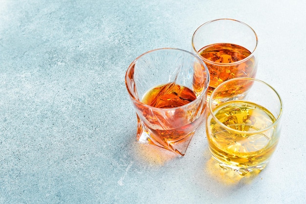 Brandy whisky et cognac dans des verres sur une table de pierre Boissons alcoolisées fortes sur un fond en béton