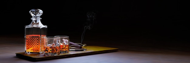 Brandy ou whisky dans un verre transparent avec des glaçons Boissons alcoolisées placées sur des sous-verres en bois Bar