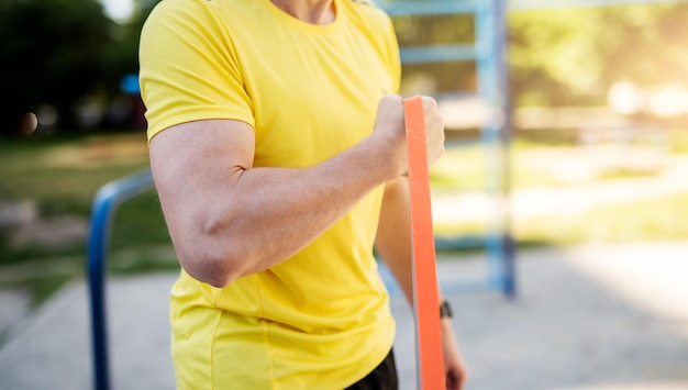 Bras musclé masculin avec bande de caoutchouc élastique dans la rue