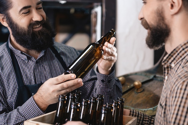 Un brasseur teste des bouteilles pour le travail d&#39;amour au remplissage de bière.