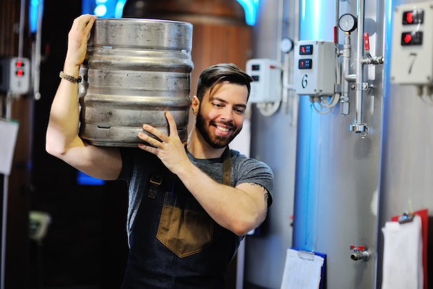 Brasseur avec un tonneau de bière en métal