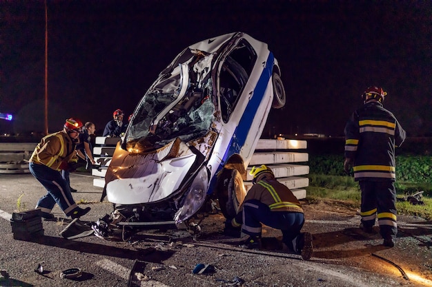 Braves pompiers essayant de libérer l'homme de la voiture accidentée.