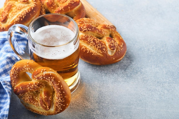 Bretzels bavarois et verre de bière blonde Menu alimentaire de l'Oktoberfest Bretzels salés traditionnels sur fond gris clair Vue de dessus avec espace pour le texte Thème de l'Oktoberfest