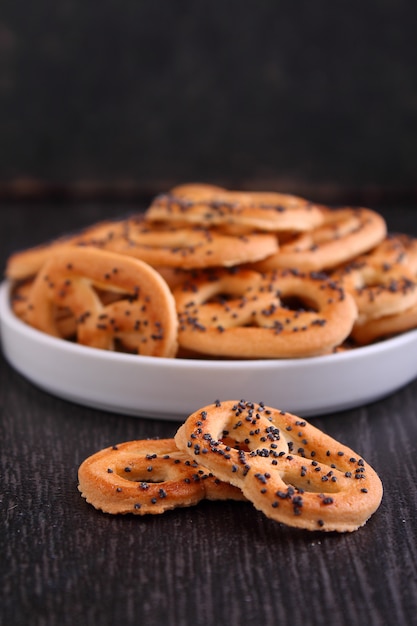 Bretzels de biscuits aux graines de pavot sur fond noir