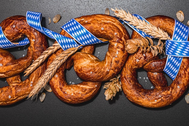 Photo bretzels concept oktoberfest avec ruban à motif traditionnel et épis de blé