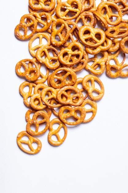 les bretzels salés sont éparpillés sur un fond blanc