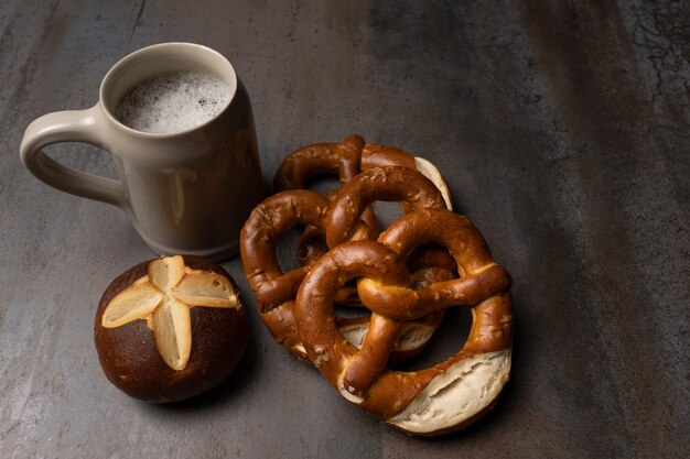 Bretzels de saucisses et pot de bière sur fond texturé