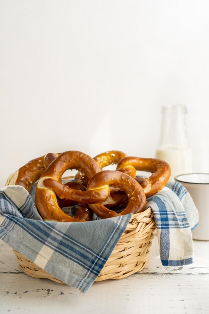 Photo brezels ou pretzels dans un panier de pain avec une serviette avec du lait