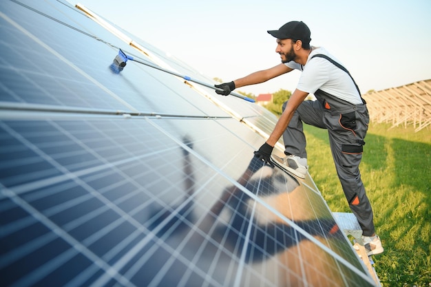 Un bricolage indien nettoie les panneaux solaires qui forment de la poussière et de la saleté