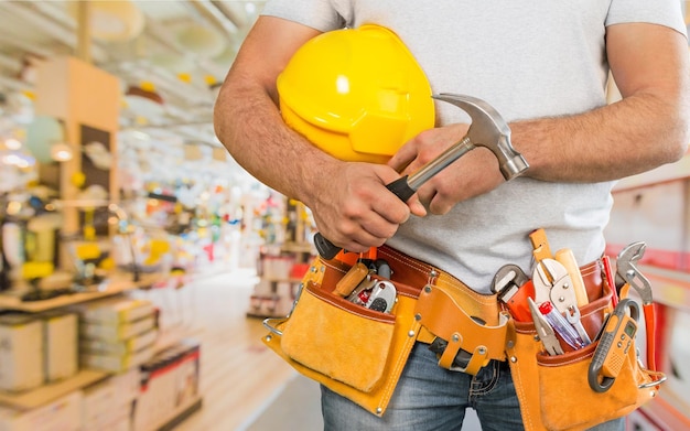 Bricoleur avec une ceinture à outils. Service de rénovation de maison.