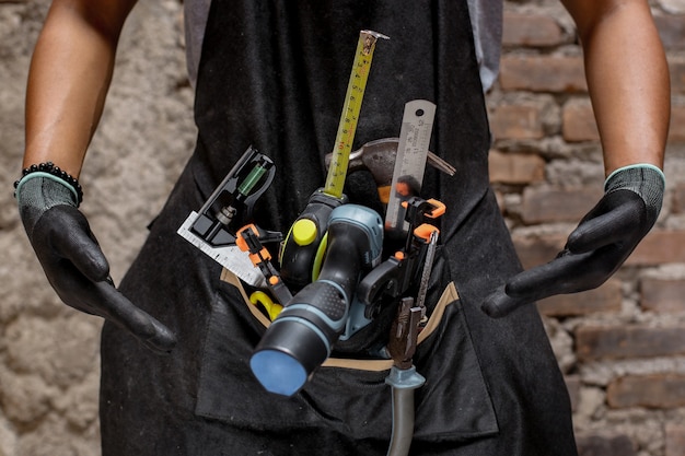 Bricoleur de constructeur avec des outils de construction pour la rénovation de maison ou le concept de fond de charpentier