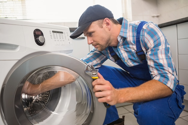 Bricoleur fixant une machine à laver