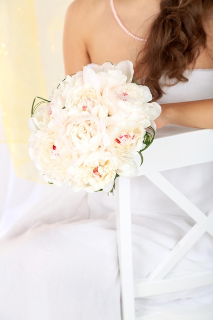 Bride holding bouquet de mariage de pivoines blanches gros plan sur fond clair