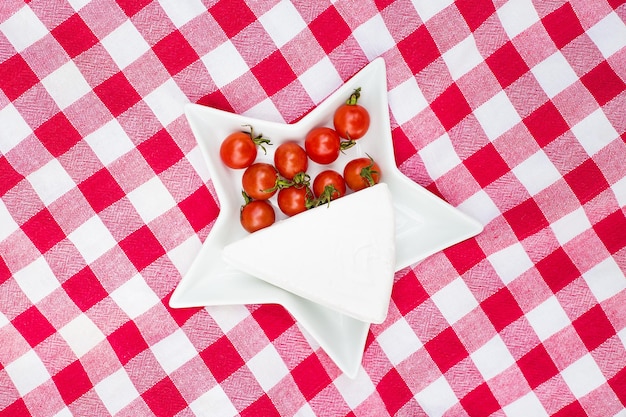 Brie et tomates cerises sur une nappe rouge