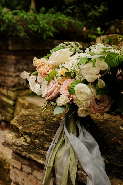 Brillant bouquet romantique de fleurs avec des rubans sur un fond clair