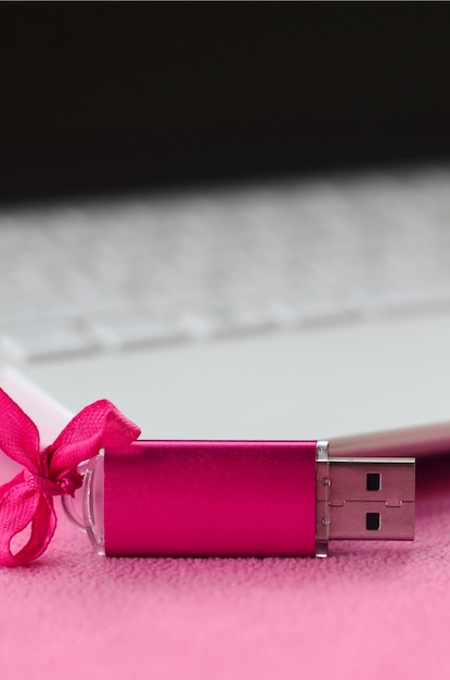 Brillant carte mémoire flash USB rose avec un arc rose se trouve