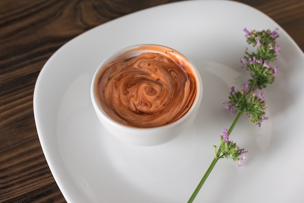 Brin d'herbes et sauce dans un bol blanc sur une table en bois. Sauce végétarienne. Sauce pour viande et poisson.