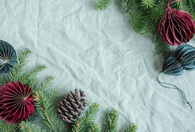 Brindilles d'épinette et décorations de Noël en papier sur le fond textile chiffonné en lin vert