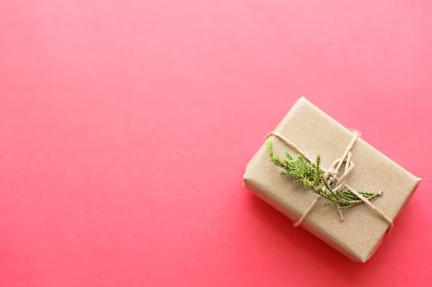 Brindilles vertes de sapin et une boîte cadeau légère sur le rose. Fond de noël.