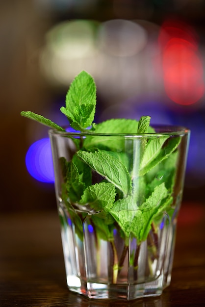 Brins frais de menthe dans un verre avec de l'eau.