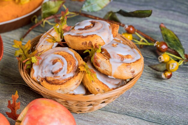 Brioches à la cannelle faites maison avec glaçage blanc et pomme.