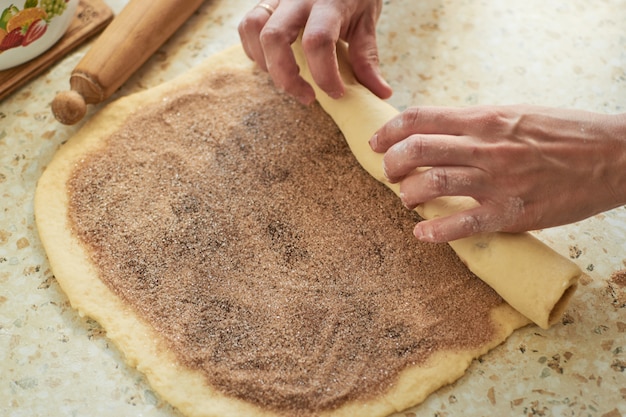 brioches à la cannelle - processus de cuisson à la cannelle fond de pâte crue.