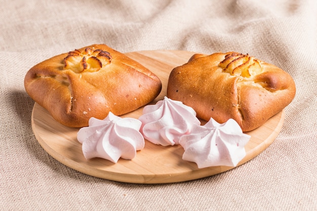 Brioches et meringues sur une planche de bois