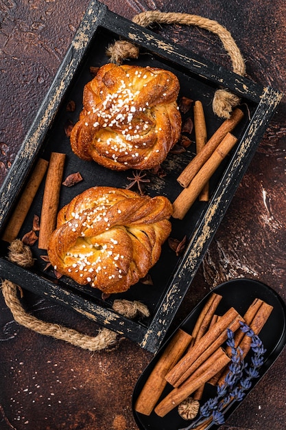 Photo brioches ou petits pains à la cannelle suédois kanelbullar fond sombre vue de dessus