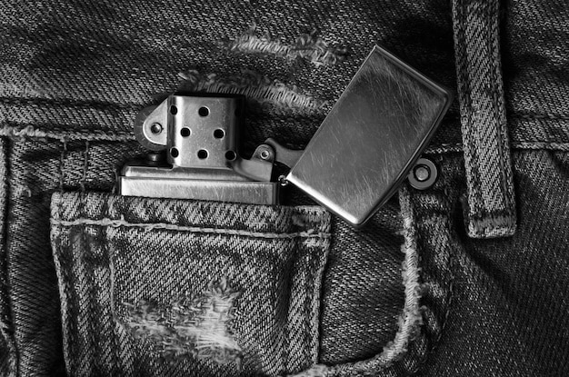 Photo un briquet en métal sur les jeans .