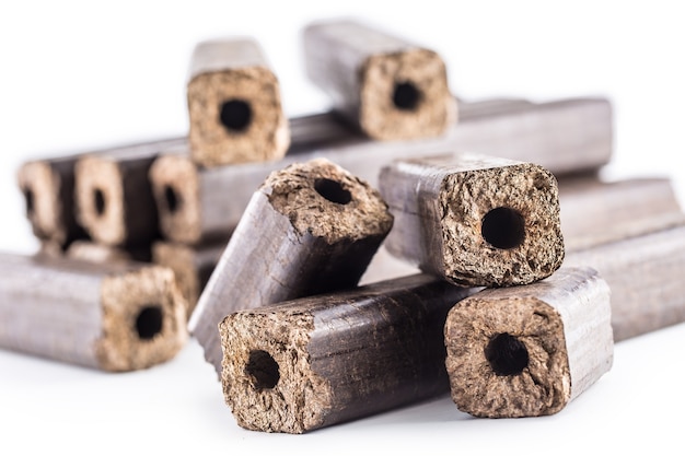 Briquettes pressées en bois Pini Kay à partir de biomasse sur fond blanc isolé.