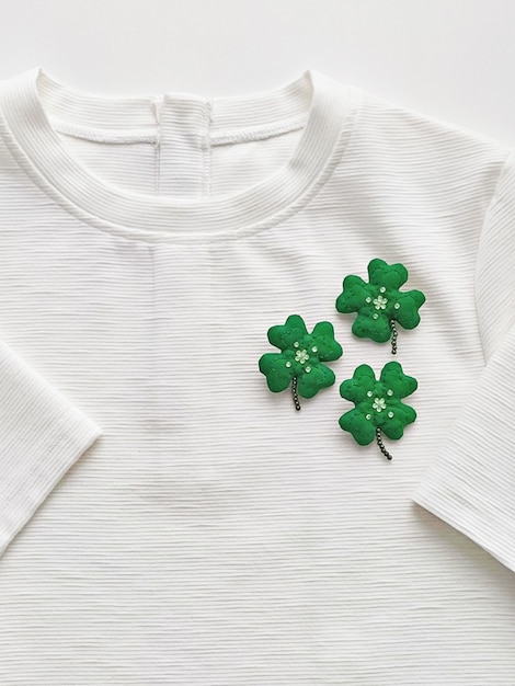 Broche feuille de trèfle à la main sur T-shirt blanc. Célébrer le concept de la Saint-Patrick