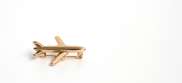 Broche En Or En Forme D'avion Sur Fond Blanc.