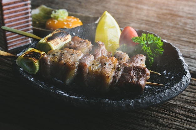 Brochette de porc grillée à la japonaise avec un faible éclairage intérieur.